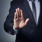 Male Victimization in Abuse: Unseen Scandal Man in suit with hand raised, signaling stop.
