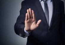 Male Victimization in Abuse: Unseen Scandal Man in suit with hand raised, signaling stop.