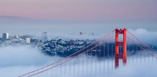Golden Gate Bridge emerging from fog with San Francisco in the background