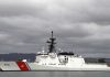 A U.S. Coast Guard ship docked under cloudy skies