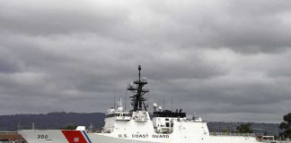 A U.S. Coast Guard ship docked under cloudy skies
