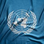United Nations flag featuring a world map and olive branches on a blue background
