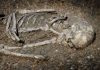 Mass Grave REVEALS Chilling Iron Age Tactic Excavated human skeleton partially embedded in soil