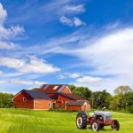 Carrie Underwood’s SHOCKING Farm Life Revelation A vintage tractor in front of a red barn on a sunny day