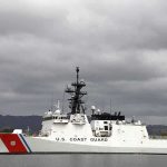 Minister’s Flag Show Sparks Outrage Overseas A U.S. Coast Guard ship docked under cloudy skies