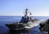 Iran’s Outrageous Plan to Control Hormuz naval destroyer sailing at sea with flag flying